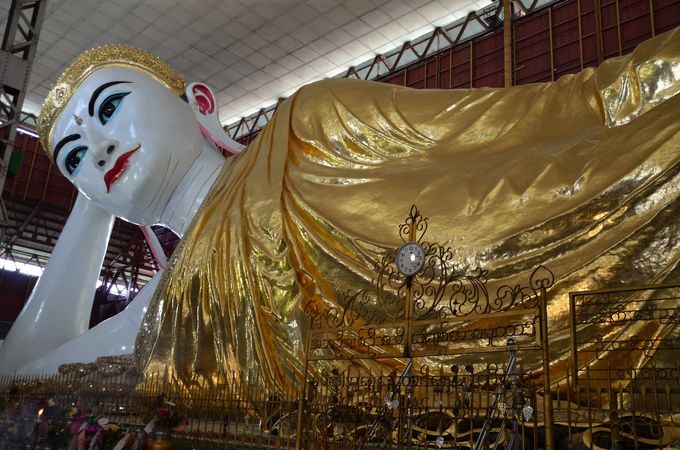 il Buddha sdraiato lungo 72 metri, nel tempio cittadino di Chauk Htat Kyi
Dedichiamo l'intera giornata giornata successiva alla visita della città, ammaliati dai mercati locali e dalla magnificenza dei templi, in testa la grande pagoda di Shwedagon, principale luogo religioso del buddhismo birmano. Lo spettacolo notturno dello grande stupa dorato  alto 98 metri è di quelli che lasciano senza fiato, solo turbato dai lavori di manutenzione della grande campana centrale, con impalcature di bambù che tuttavia sono ben celate e tolgono solo parzialmente la spettacolarità del quadro. 
